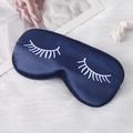 Dark blue satin sleep mask with eyelash print on a soft white plush background - Navy Blue