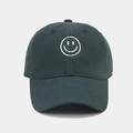 Detailed view of white smile face embroidery on dark green cotton baseball cap texture - Dark Green