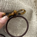 Gros plan d'un chouchou avec nœud en écaille de tortue et élastique marron sur lin beige - Nœud en Acétate-Écaille Foncée