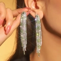 Elegant long silver tassel earrings with sparkling green and white rhinestones on model - 3D Style / Green White Gradient