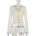 Close-up of cream blouse featuring elegant ruffled edges and lace-up front ties detail - S / Apricot