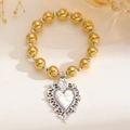 Detail eines Goldperlenarmbands mit einem antiken silbernen Hohlherz-Anhänger im Goth-Stil - Engelrelief-Herzarmband (10419) / Gold Beads With Antique Silver Charms