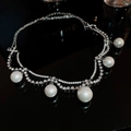 Macro di una collana di perle a doppio strato con strass argentati su sfondo nero - Argento a Doppio Strato