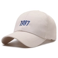 Casquette de baseball en coton beige avec broderie bleue 1987 sur fond blanc - Taille unique / Beige