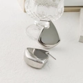 Macro shot of silver irregular geometric stud earrings with high-polished mirror finish - Silver