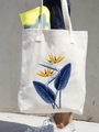 Cream canvas tote bag featuring bird of paradise floral print worn over the shoulder - Bird of Paradise Flower