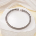 Bracciale rigido in acciaio inossidabile intrecciato argento su pietra ed elegante sfondo - Argento