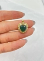 Gros plan d'un pendentif cœur doré avec pierre verte et cristaux de zircone - Or + Vert