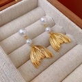 Dettaglio di orecchini a coda di sirena dorati con doppie perle in un portagioie - Stile Nappa Perla Coda di Pesce con Perno in Argento S925 / Oro