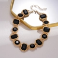 Close-up of vintage geometric gold chain necklace with black crystal rectangle accents - Black Gold Geometric Necklace