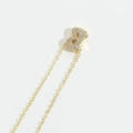 Macro shot of gold initial B pendant with shimmering cubic zirconia on a delicate chain - Letter B