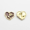 Macro detail of two heart-shaped charms with purple enamel and golden rose pattern - Brown-Gold