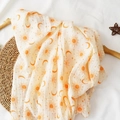 Muslin cotton baby swaddle blanket with orange sun and moon prints in soft off-white - Beige Sun Moon Star