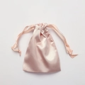 Elegant pink satin drawstring gift bag with silky texture on light grey background - Gold Pink