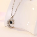 Macro shot of silver crescent moon necklace featuring micro-pave zircons and projection gem - Moon White Gold Color