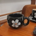 Hand-painted black ceramic mug featuring textured white floral patterns on a wooden table - Black Background Large Petal