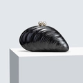 Detail of black marble acrylic shell clutch with pearl clasp on white podium - Black