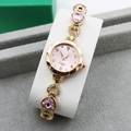 Detail of gold-plated bracelet watch with pink heart stones and crystal accents - Rose Gold + Pink