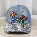 Macro view of blue denim baseball cap featuring colorful gemstone butterfly and rhinestones - No.9/Light Blue Denim/Gemstone Butterfly