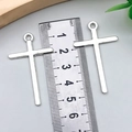 Vista dettagliata di due ciondoli a croce argento di 48mm x 28mm con righello per scala - Croce Argento Antico 27x45mm