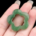 Green aventurine quartz hollow plum blossom flower pendant held in hand for size view - Green Aventurine