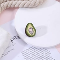 Cartoon avocado enamel pin featuring a pink character figure on a display stand - Avocado (Personified Avocado)