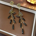 Macro shot of long fringe earrings featuring black crystal drops and mesh bow details - Silver Earring Post-Black