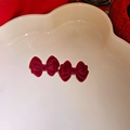 Close-up of elegant wine red velvet bow earrings on a cloud-shaped display tray - Flocking Velvet Bow Tie Ear Jewelry