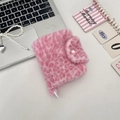 Detailopname van een roze pluche portemonnee met luipaardprint en knoopsluiting. - Lichtroze