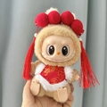 Labubu plush doll wearing a red Chinese-style outfit with festive tassels and pompoms - Red Thread Bellyband Set / First And Second Generation Keychains Are Compatible With La Cloth Dolls. Dolls Not Included.