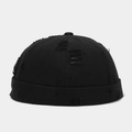 Detail showing distressed cotton canvas texture and ripped holes on the black brimless cap - Adjustable / Black