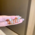 Orecchini multistrato placcati in oro con zirconi e perle bianche mostrati sulla mano - 21# Perno in Argento - Triplo Cerchio Perla Oro