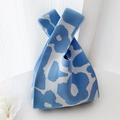 Blue and white knit wrist bag featuring abstract floral pattern and woven handle - Blue Floral