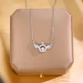 Elegant silver angel wings crown necklace with moving stone on a silk jewelry box - Silver Dancing Wings (Style 2)