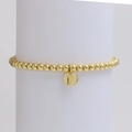 Detail of a gold beaded bracelet featuring a round charm with the letter F engraving - Letter F (DB240603-F)