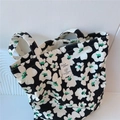 Primo piano della borsa tote in tela con stampe floreali bianche e nere e accenti verdi - Nero Con Grandi Fiori Verdi E Bianchi