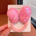 Detailed view of a pink sequined butterfly hair tie with elastic fabric on a display card - Pink Butterfly