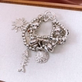Detail of vintage multi-layer bracelet with sun, fish bone and shell charms - Silver