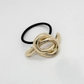 Elegant black elastic hair tie featuring a polished gold alloy knot ornament for women - Knotted Style Gold