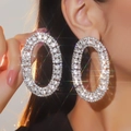 Luxurious silver oval hoop earrings with sparkling crystals shown in a brilliant starburst effect - Full Diamond Oval Hoop / Silver