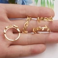 Dettaglio di anello foglia placcato oro 14K con zirconi su mano con fiori - Base per Anello Foglia Oro 14K
