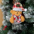 Plush brown bear Christmas ornament with plaid hat and scarf hanging on a snowy tree - Christmas Bear