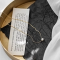 Elegant gold chain necklace with a round claw-set crystal on a minimalist tray - Gold
