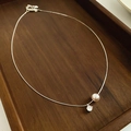 Primer plano de un collar de cadena de serpiente plateada con perla y circón en madera - Estilo de Colgante de Perla y Circonio / Plateado