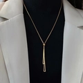 Collar largo dorado minimalista con borla de triángulo geométrico mostrado en modelo - Dorado