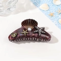 Dettaglio molletta a conchiglia con perle e strass su sfondo a tema oceanico - 10.5cm / Caffè Stellato