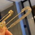 Detail shot of a luxury gold safety pin brooch with shimmering inlaid crystals - Simple Full Rhinestone Style (Gold)