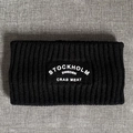 Close-up of black ribbed knitted headband featuring white Stockholm embroidered text - Black