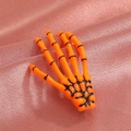 Gothic orange skeleton hand hair clip with black detailing on a purple silk background - Orange (8617)