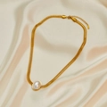 Close-up of golden braided stainless steel necklace with round pearl on silk background - Pearl Necklace